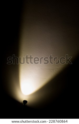 Dark Wall Illuminated from the Left Corner Spotlight Lamp, black background