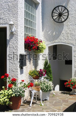 Cozy mediterranean garden with geranium flower pots