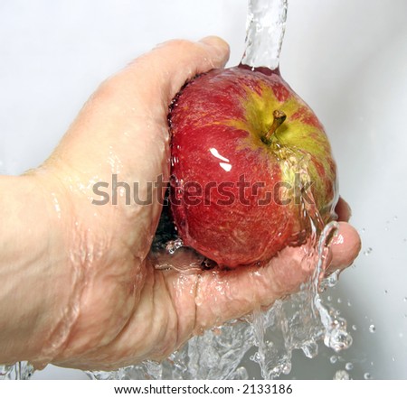 Apple being rinsed under a tap - great detail of splashes