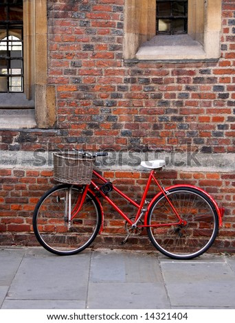 Old red bike with basket in Cambridge