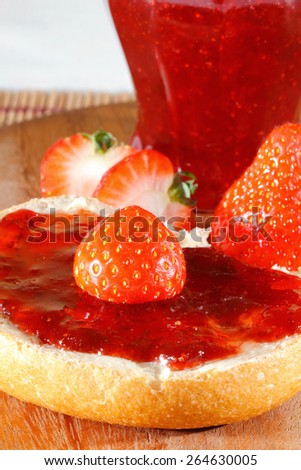 Strawberries, strawberry jam, bread with jam on a wooden board