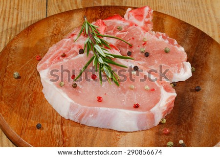 Raw pork chop on a wooden chopping board