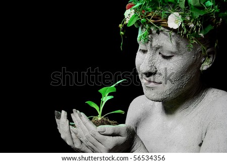 Mother earth holding plant sprout in her hands. Black background. studio shot.