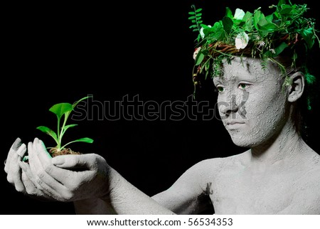 Mother earth holding plant sprout in her hands. Black background. studio shot.