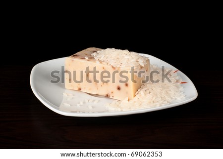 A piece of handmade soap with rice on the plate.