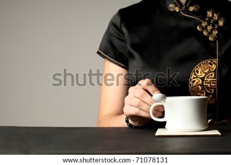 Woman in national japanese clothes with a cup of tea. No face.