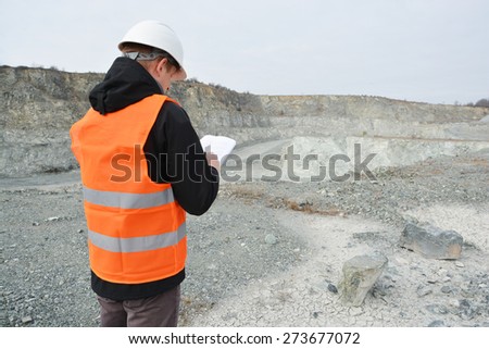 Worker and quarry in background