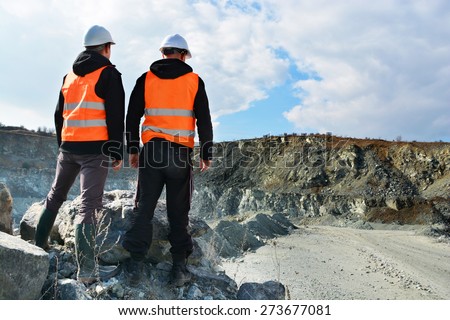 Two workers and quarry in background