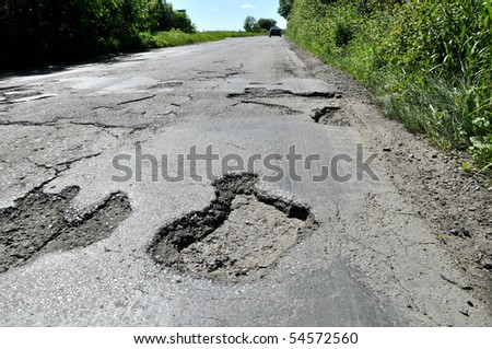 Road destroyed after winter. A hole in the road.