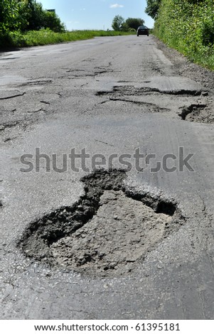 Road destroyed after winter. A hole in the road.