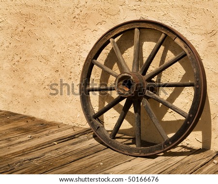 wagon wheel, an iconic symbol of the American West, sits on a wooden 