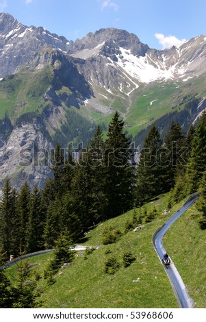 An alpine slide winds its way down the mountain, high in the Swiss Alps