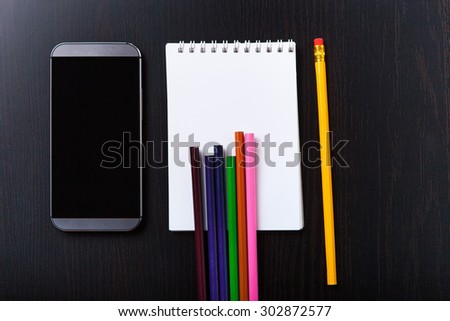 A recorded book, pen and mobile phone on the table.