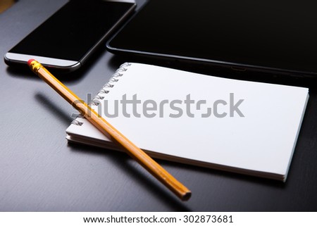 A recorded book, pen and mobile phone on the table.