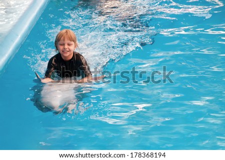 Riding on a dolphin at the dolphin therapy session