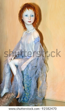 KIEV, UKRAINE - JANUARY 09: A collectible doll, which resembles red-haired girl in light cape, is on display at the Angel Age exhibit of Author\'s Dolls on January 09, 2012 in Kiev, Ukraine.