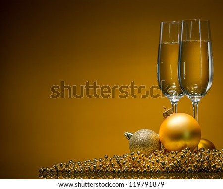 golden Christmas balls and champagne glasses on a gold background