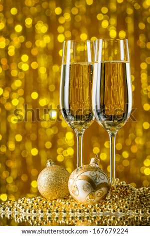 glasses of champagne and Christmas balls on a gold background