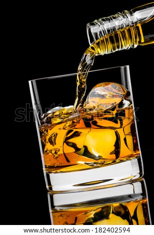 Pouring whiskey drink into glass