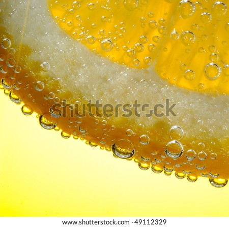 Bubbles on a lemon segment in soda water