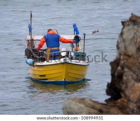 Crab and lobster Fisherman putting his pots out off the isle of Anglesey North Wales