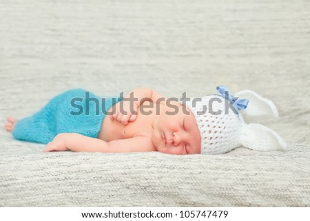Newborn baby.Funny sleeping newborn child. Bunny cap on head of boy. Soft focus, shallow DoF