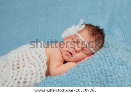 Close-up portrait of a beautiful sleeping baby on blue.0-7 deys baby. New born baby. Soft focus.