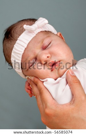 Mother holding newborn baby girl. A week old baby in the comfort of moms arms