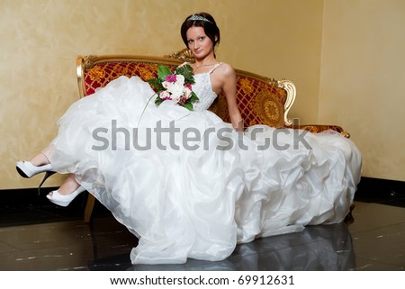 Sexi bride relaxing on love seat.