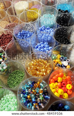 many transparent jars full of colored beads