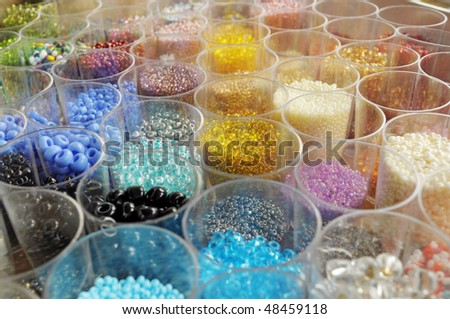 many transparent jars full of colored beads