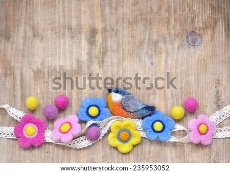 Wooden background with lovely hand felted flowers and bird