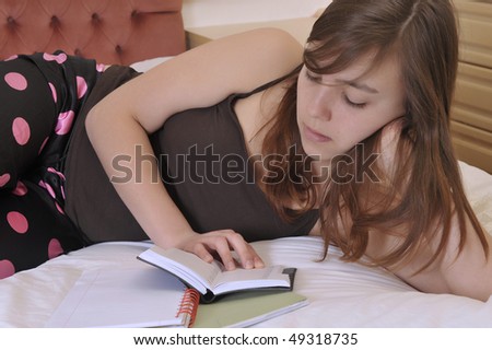 Teenager reads in her bedroom