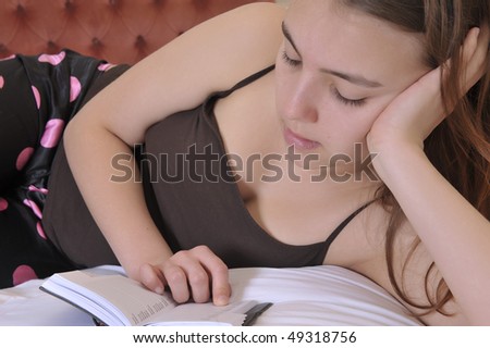 Teenager reads in her bedroom