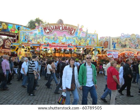 DUSSELDORF, GERMANY - JULY 24: Unidentified visitors near a horse racing game at Kirmes on July 24, 2010 in Dusseldorf, Germany. Kirmes is the biggest fair on the north Rhein in Germany.