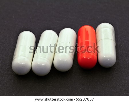 One red pill among four white pills