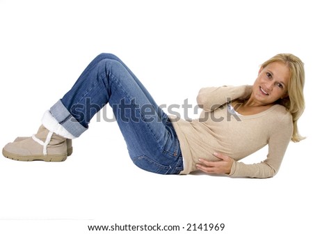 Beautiful blonde woman full-length portrait laying down on her side in casual winter clothes. Image isolated on white.