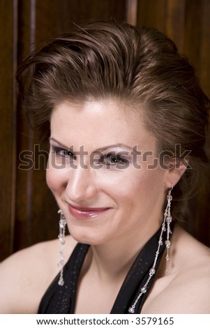 Beautiful young brunette woman dressed in an elegant evening gown smiling for the camera,