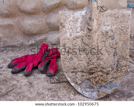 Dirty shovel and red gloves. After the working day