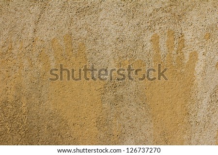prints of children\'s hands on a background of concrete