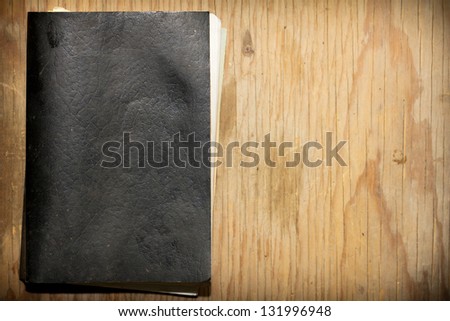 The old, wise book lies on a wooden background