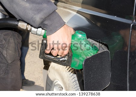 male hand refilling the car with fuel on a filling station