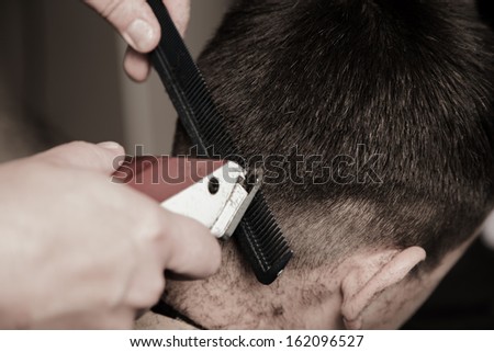 Barber cutting hair with clipper