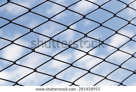 metal fence against the blue sky with clouds