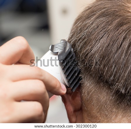 Close up of a male student having a haircut with hair clippers