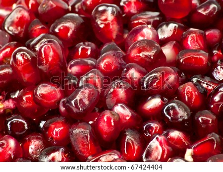 Extreme close up background of a red juicy ripe pomegranate fruit seeds
