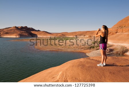 Young woman having a morning work out along the shore of Lake Powell in the southwestern US desert.
