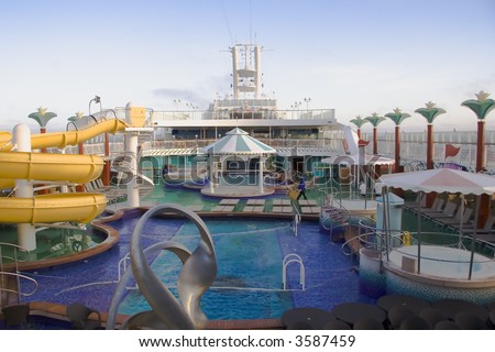 The top deck of a cruise ship with water slides, hot tubs, pool, and other items