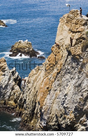Cliff diving in Acapulco, Mexico with diver about to enter the water