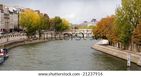 Autumn colors along the Seine River in Paris, France with overcast skies.